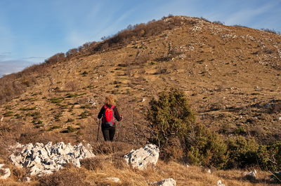 Rear view of mature woman hiking in the mountains