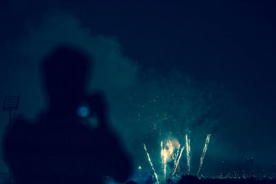 Silhouette man against firework