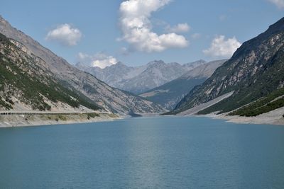 Scenic view of lake by mountains against sky