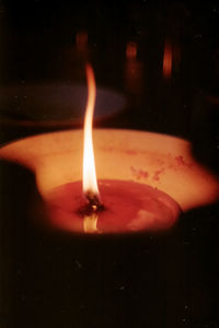 Close-up of lit candle in the dark