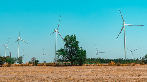 Windmill on field against clear sky