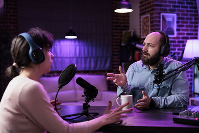 Man and woman podcasting at studio