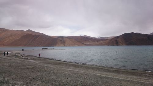 Scenic view of lake by mountains against sky