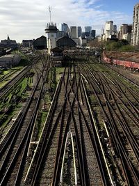 Railroad tracks in city against sky