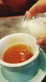 Close-up of hand holding bowl of soup