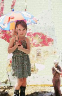 Portrait of cute girl standing against wall