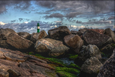 Rocks by sea against sky