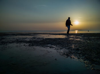 Man standing on beach against sky