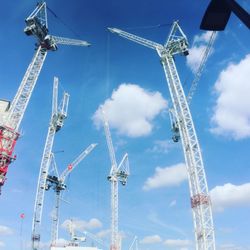 Low angle view of cranes against sky