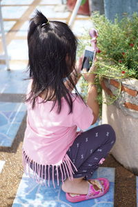 Close-up of girl taking picture of plants