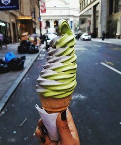 Woman holding ice cream cone on street