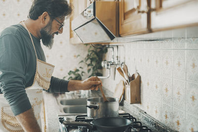 Side view of man working in kitchen