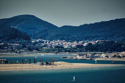 Scenic view of sea and mountains against clear sky