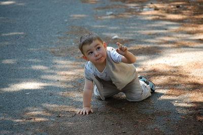 Boy kneeling on road