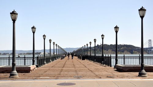 View of street lights against clear blue sky