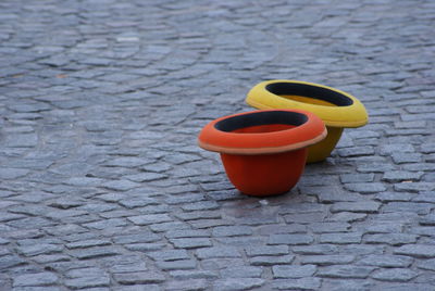 High angle view of red and yellow containers on cobbled street