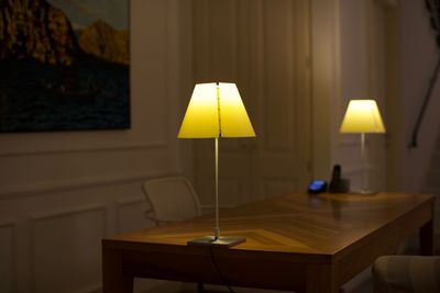 Close-up of electric lamp on table at home