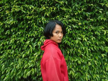 Side view portrait of woman standing by plants