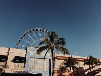 Low angle view of ferris wheel against clear sky