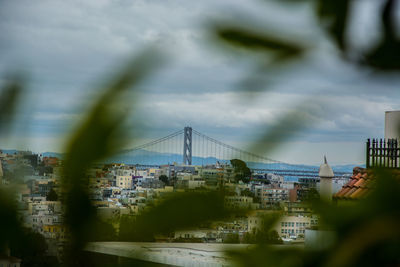 Bridge over cityscape against sky