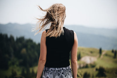 Rear view of woman standing against sky