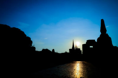 Silhouette of temple building against sky during sunset