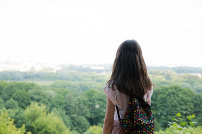 Rear view of woman standing against sky