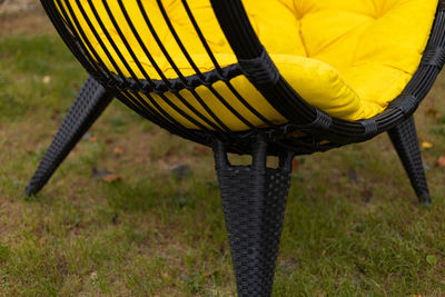 Cocoon armchair with yellow cushion on the lawn