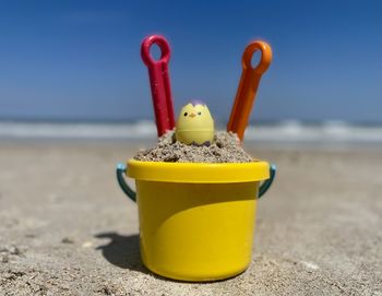 Close-up of yellow toy on beach