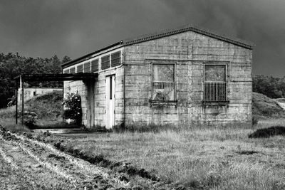 Abandoned house on grassy field