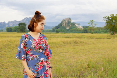 Woman standing on field against sky