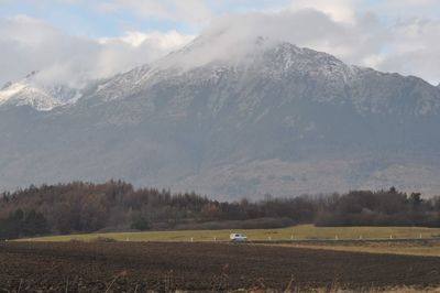 Scenic view of field and mountains against sky