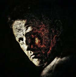 Close-up portrait of man against black background