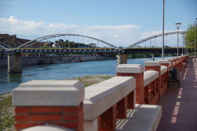 Bridge over river in city against sky