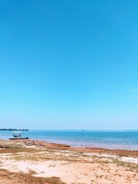 Scenic view of beach against clear blue sky