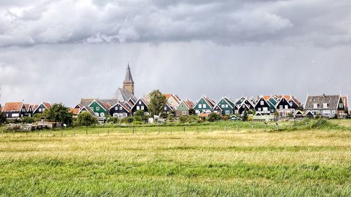 Panoramic view of houses on field against sky