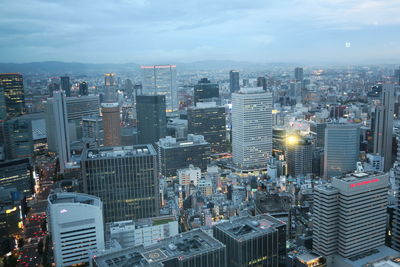 Aerial view of buildings in city against sky