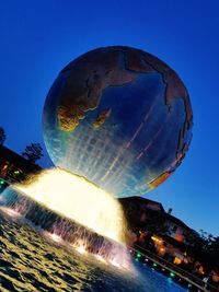 Low angle view of illuminated water against clear sky at night