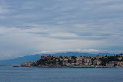 View of buildings in sea against cloudy sky