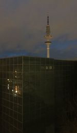 Communications tower against cloudy sky