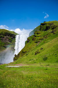 Scenic view of waterfall against sky