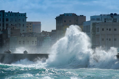 Water splashing in sea against sky