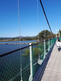 Bridge over river against clear blue sky