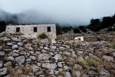 Historic building by tree mountain against sky