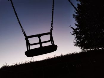 Low angle view of swing ride against sky