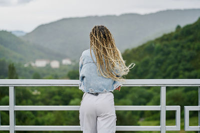 Rear view of woman looking at railing