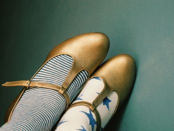 Low section of woman wearing golden shoes