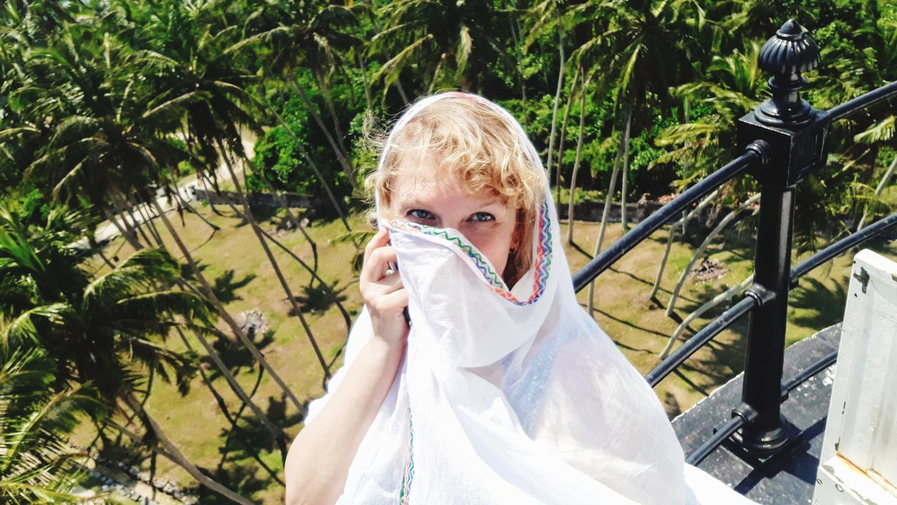 one person, plant, real people, blond hair, portrait, tree, front view, looking at camera, hair, nature, day, childhood, leisure activity, lifestyles, women, child, headshot, hairstyle, obscured face