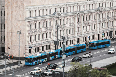 Traffic on road by buildings in city