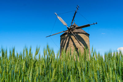 Traditional windmill on field against sky